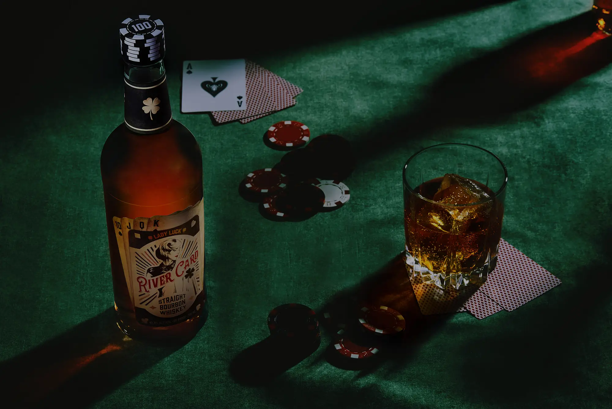 Whiskey, poker chips, playing cards on table.